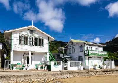 Front view of The Cholson Chalets beachfront eco-luxury hotel on a bright, sunny seaside day